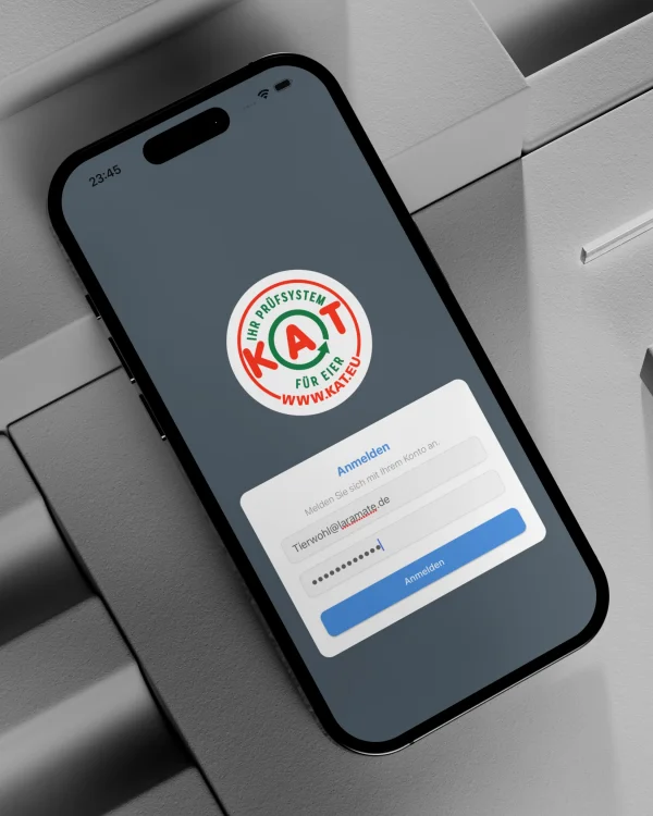 React development in Bonn by Laramate GmbH. Smartphone showing a KAT certification app login screen for quality assurance. Custom app, end-to-end mobile app development built by Laramate GmbH in the poultry industry.
